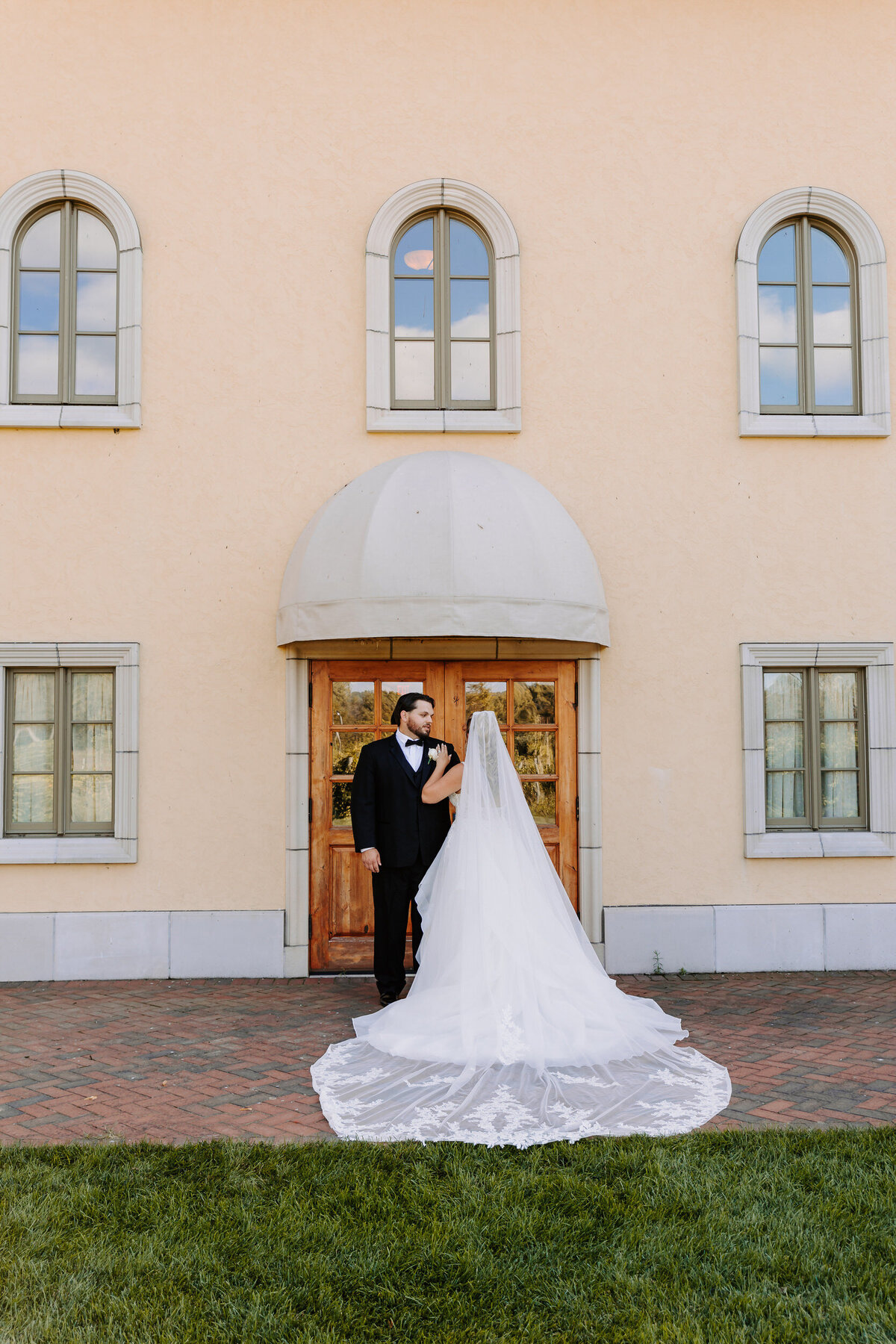 A bride and groom standing in front of a building together