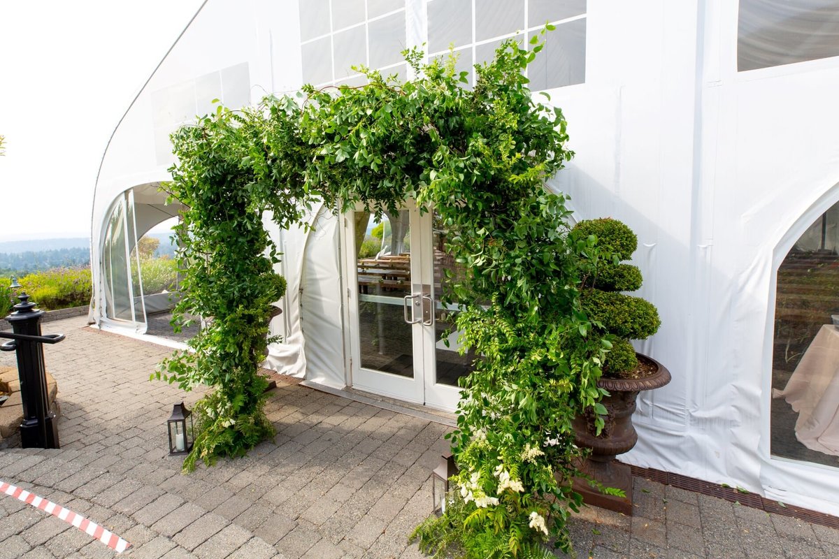 Large greenery arbor at entrance to wedding tent at Newcastle Golf Club