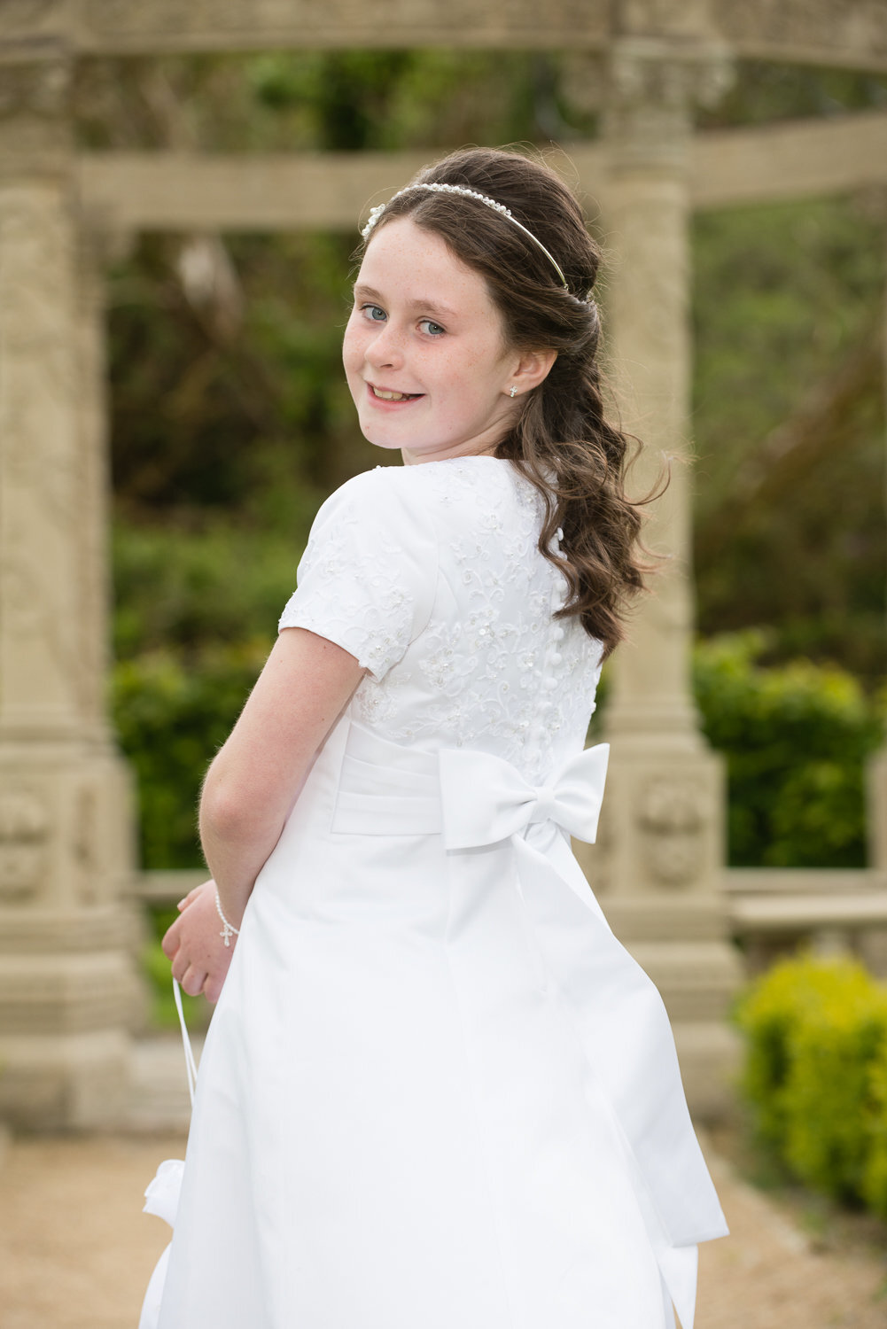 communion portrait of a girl wearing a white dress in the garden of ballyseede castle