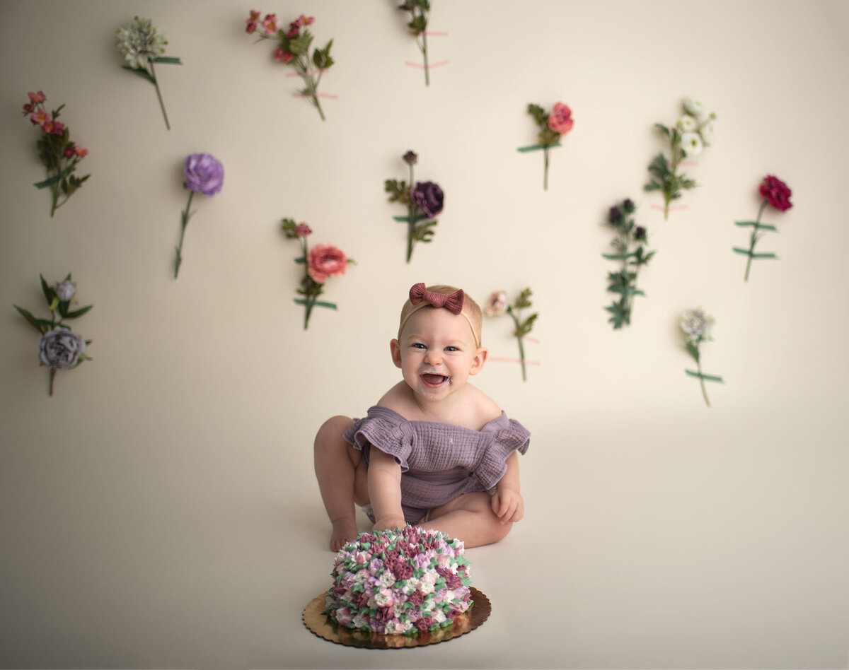 baby smiling in front of cake at her st. louis cake smash session