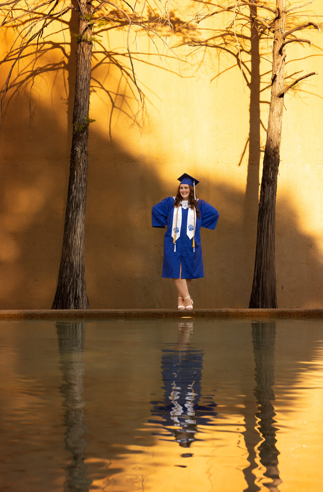 girl-in-cap-and-gown-standing-with-reflection-fort-worth-water-gardens