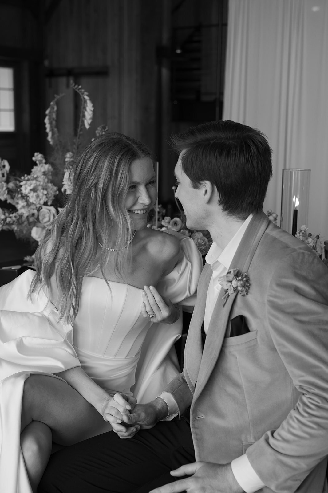 Black and white photo of bride and groom looking at each other and laughing