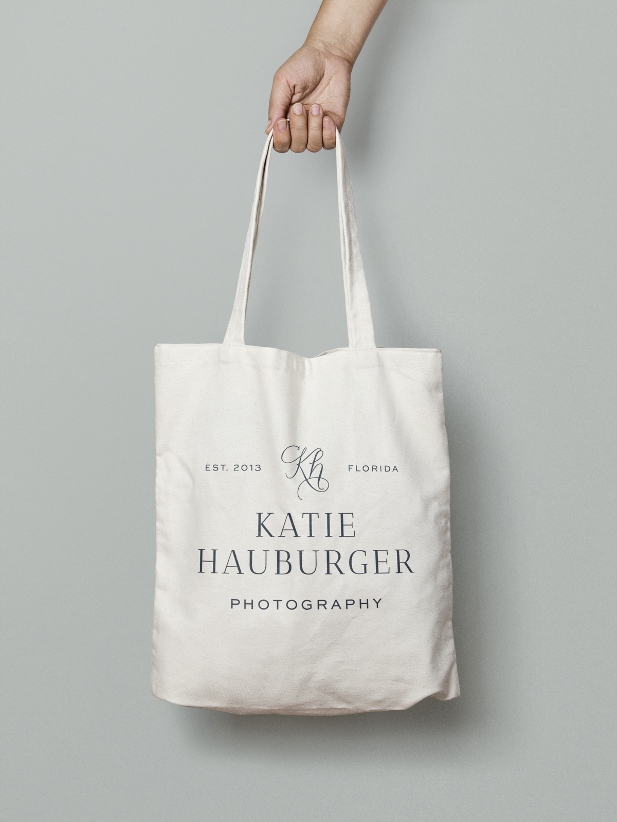 a mockup showing a photographer's logo on a tote bag