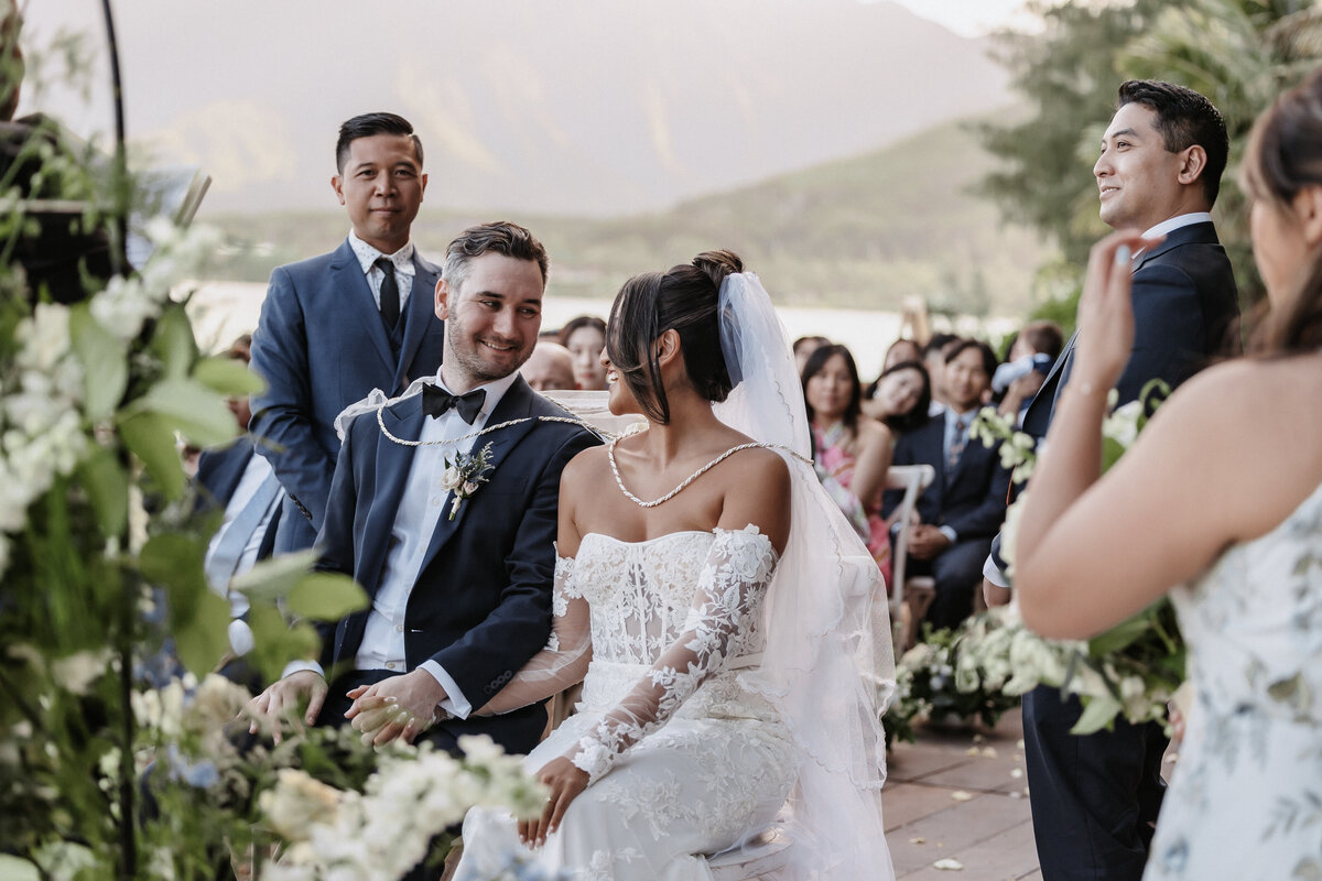 Bride and groom in Filipino wedding ceremony seated next to each other on the beach