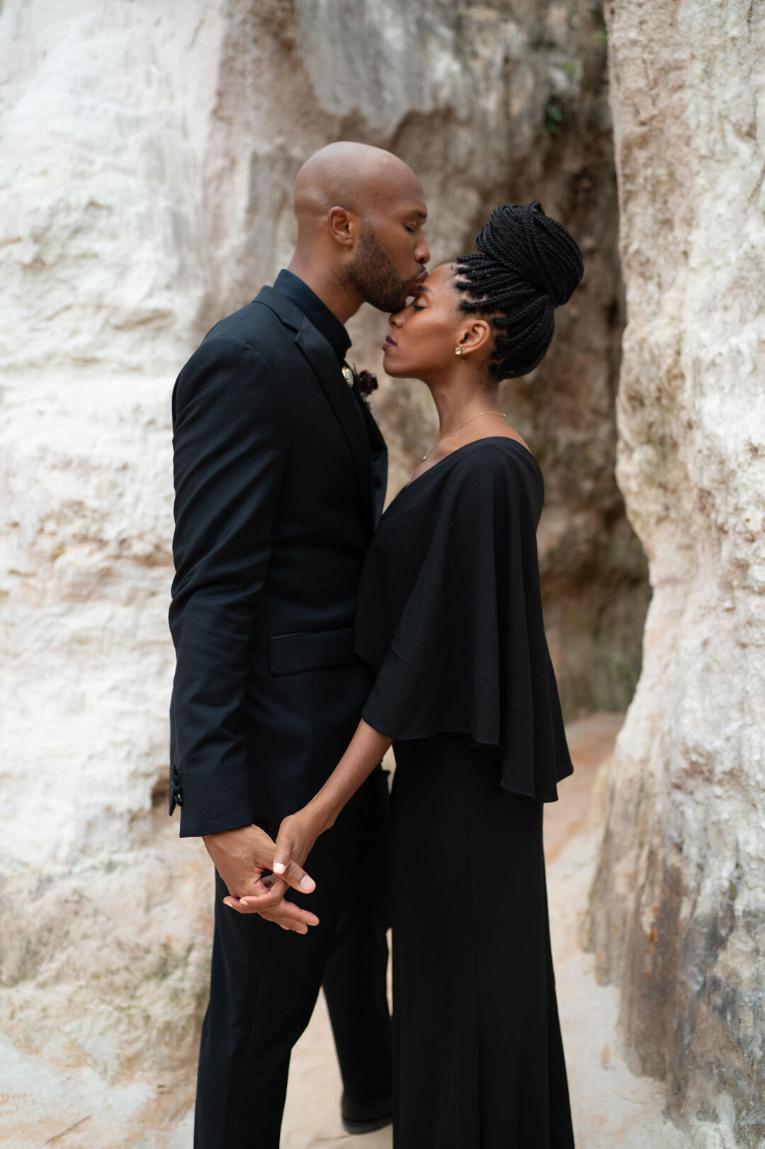 Black couple wearing black outfits embracing in the desert