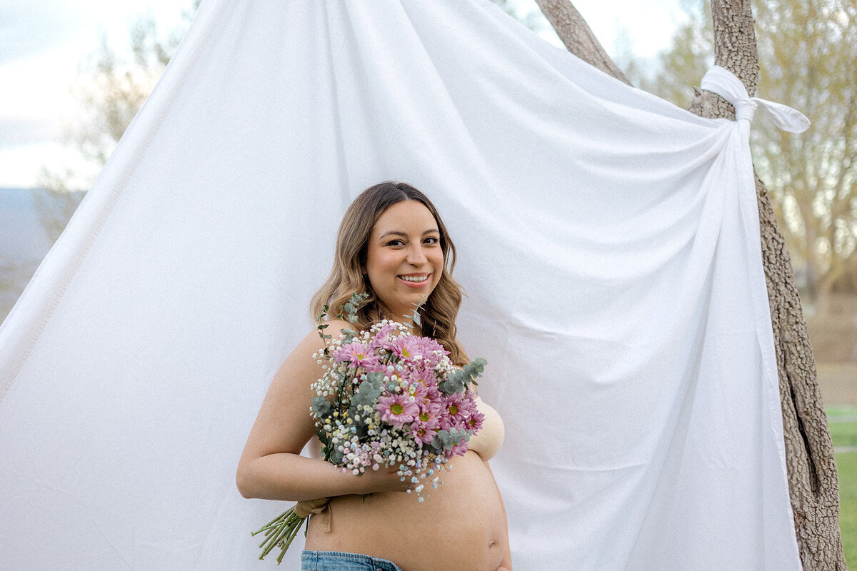 A woman smiles while holding flowers