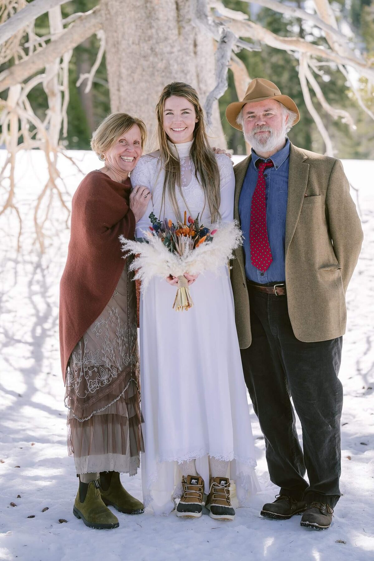 Bride with her parents after winter elopement ceremony in Palisades tahoe ceremony photographed by Annie X Photography