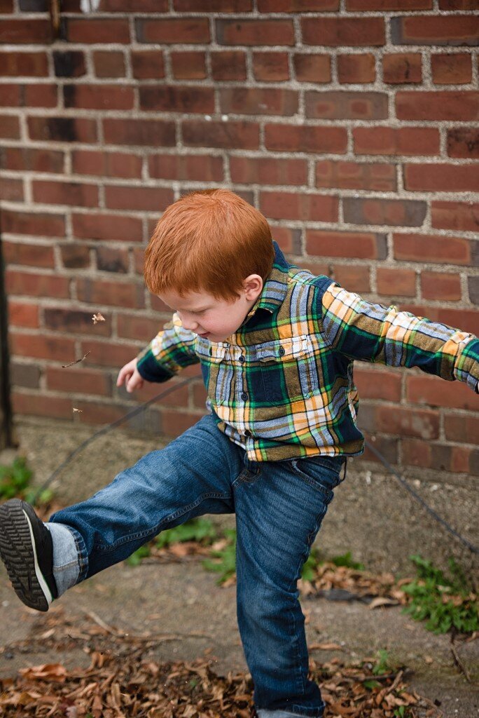 boy kicking leaves