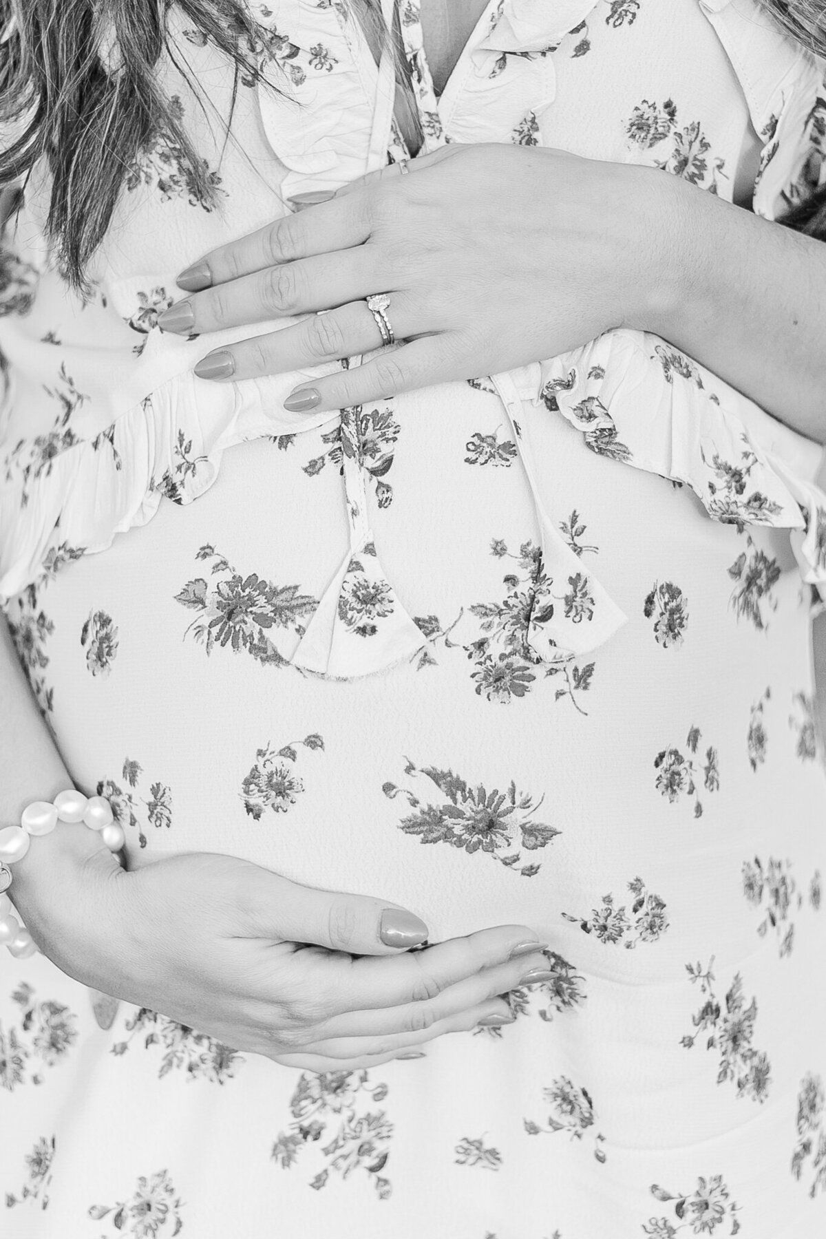 close up black and white picture of mom holding pregnant belly during maternity session