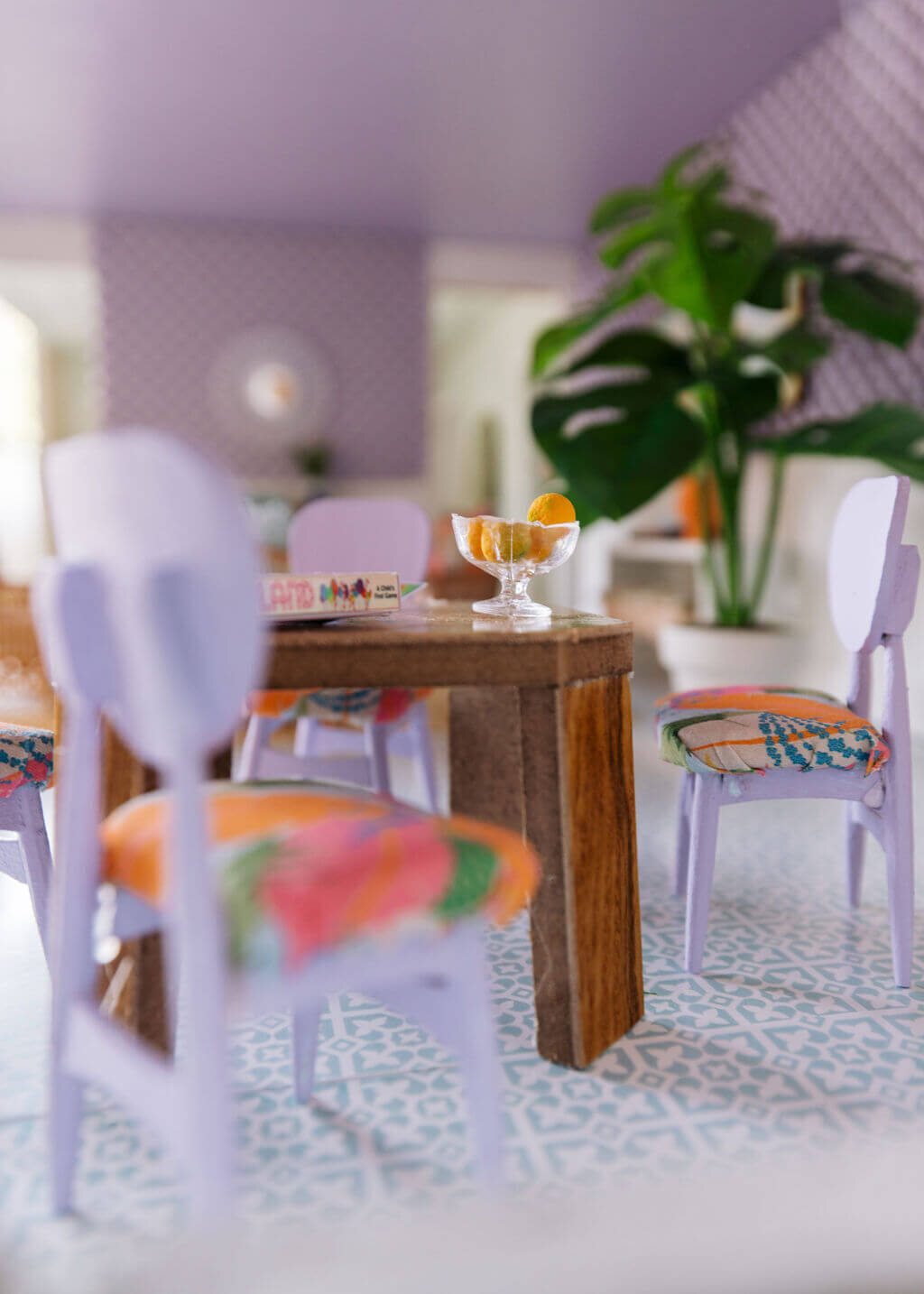 oyster creek studios petite palm beach dollhouse miniature white chairs with tropical cushions around a wooden table with large plant in dining room