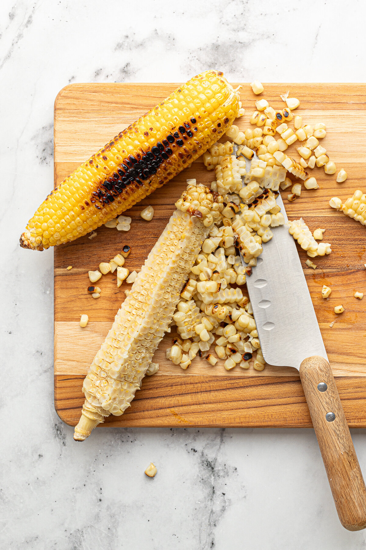 roasted corn cut off the cob on a wooden cutting board