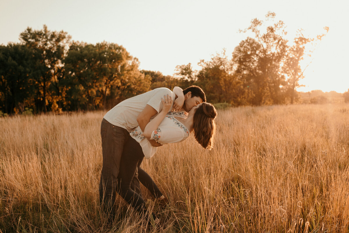 couple hugging and kissing in wheat field
