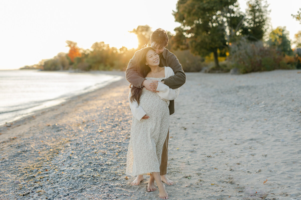 Pregnant couple on the beach by Toronto Newborn Photographer