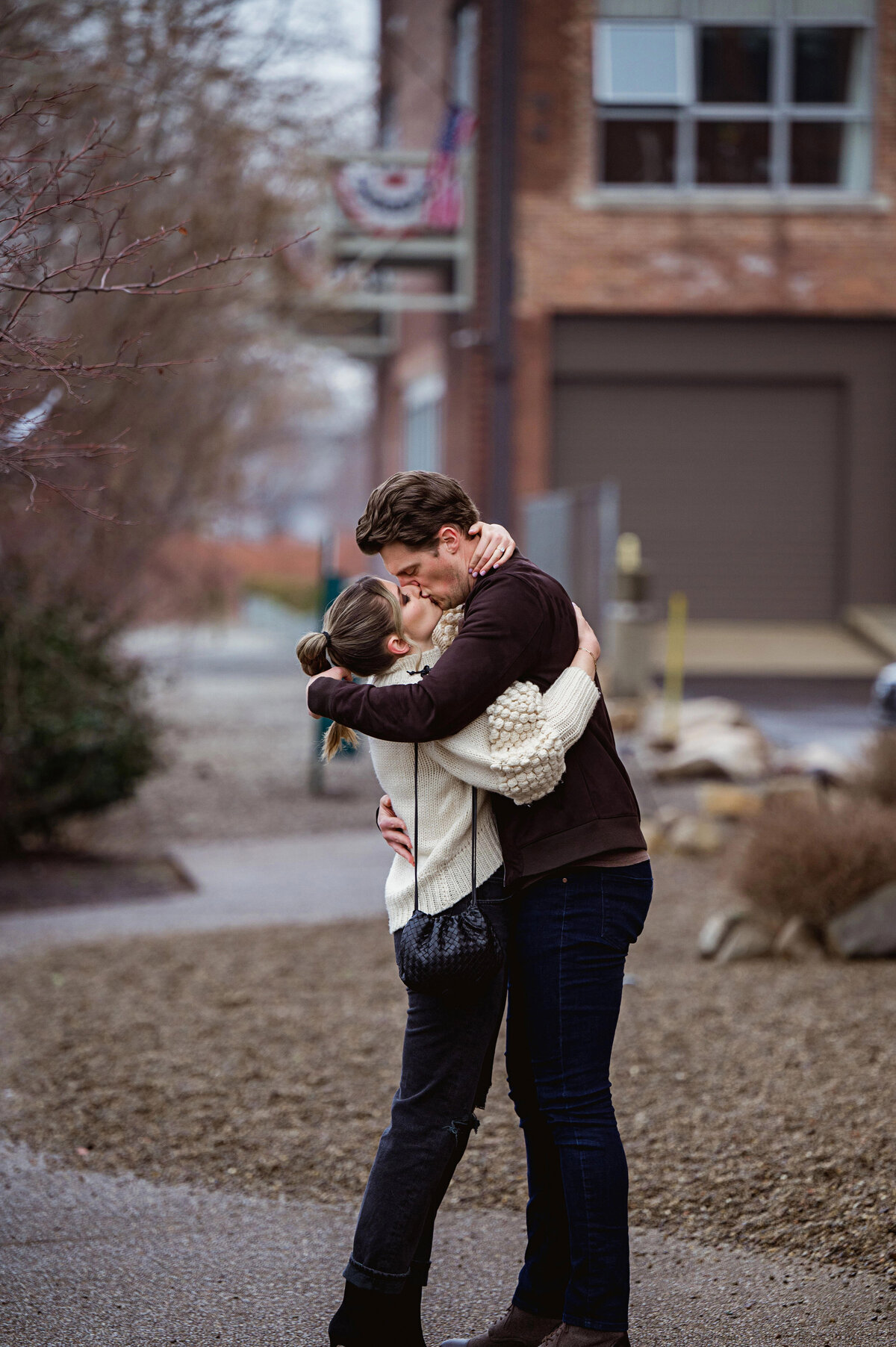 couple kissing after they got engaged in pittsburgh strip district