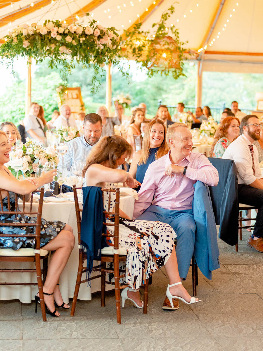 During a wedding reception at Castle Hill Inn in Newport, RI, guests laugh.
