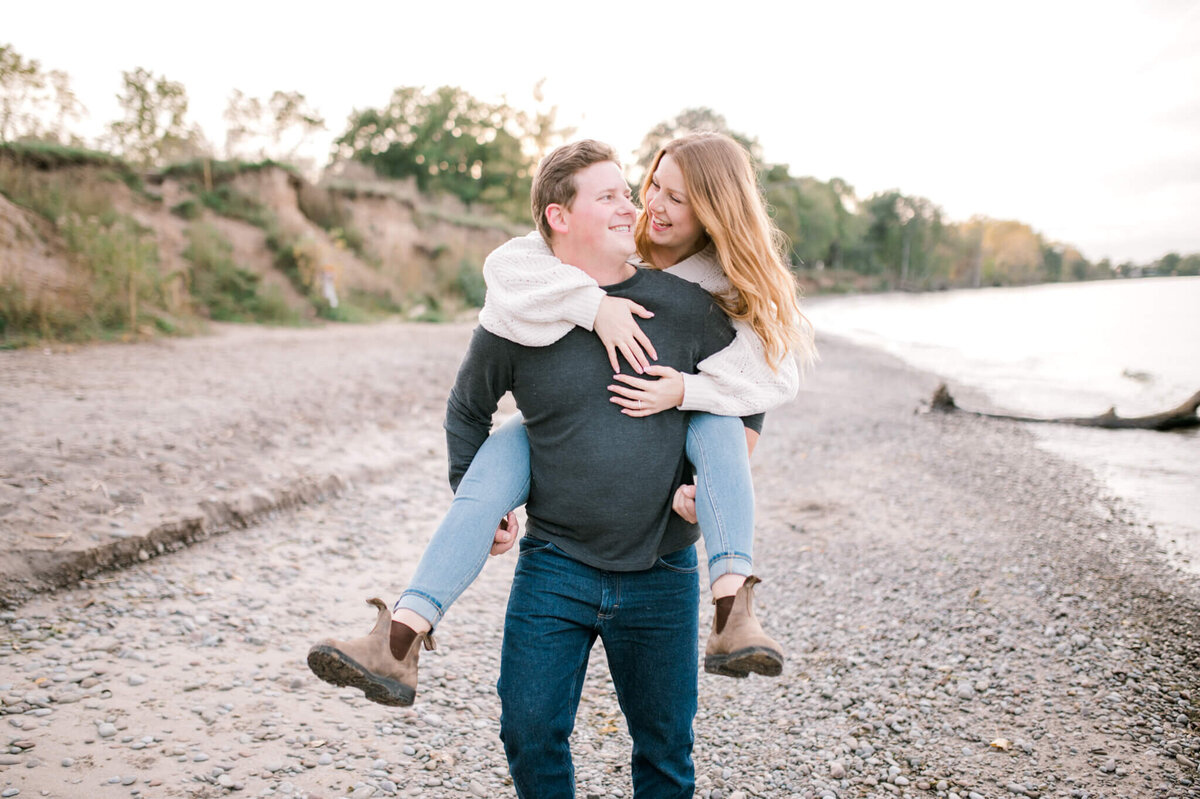 Man holding woman on his back for engagement session