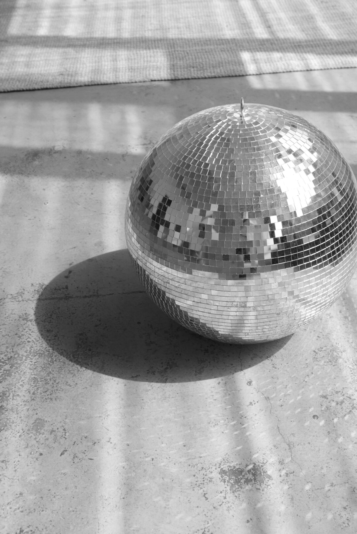 Mirror ball in black while casting a shadow on the floor
