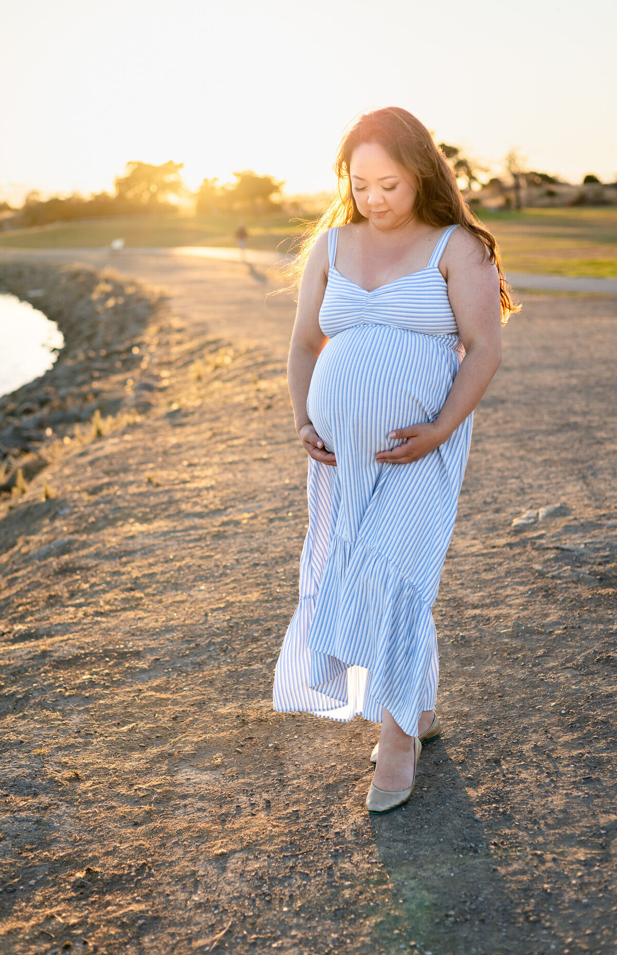 Mother-to-be walking along the bay trail during golden hour, cradling her bump — Bay Area Maternity Portfolio - Ellobelle Photography Family Photographer