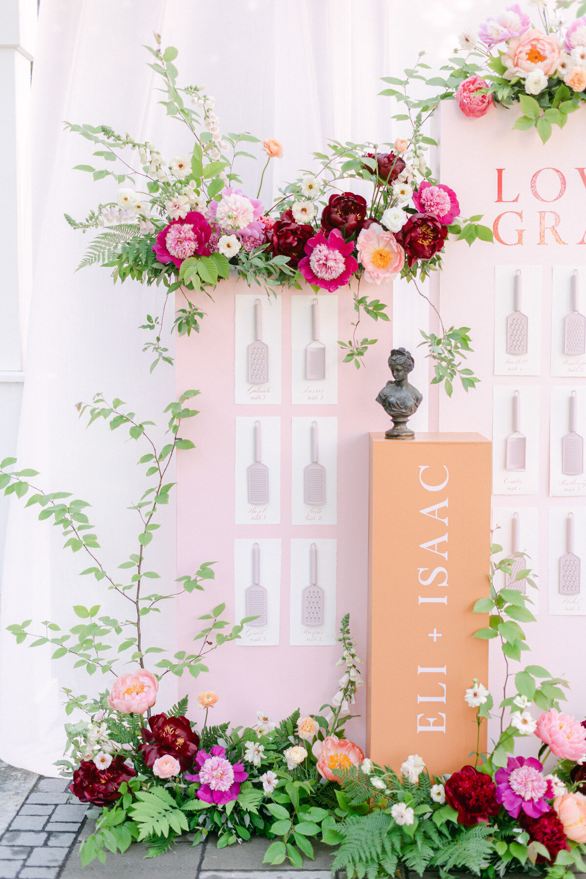 Two lush arrangements of pink flowers decorate a place card display at a Stonehaven Manor wedding.