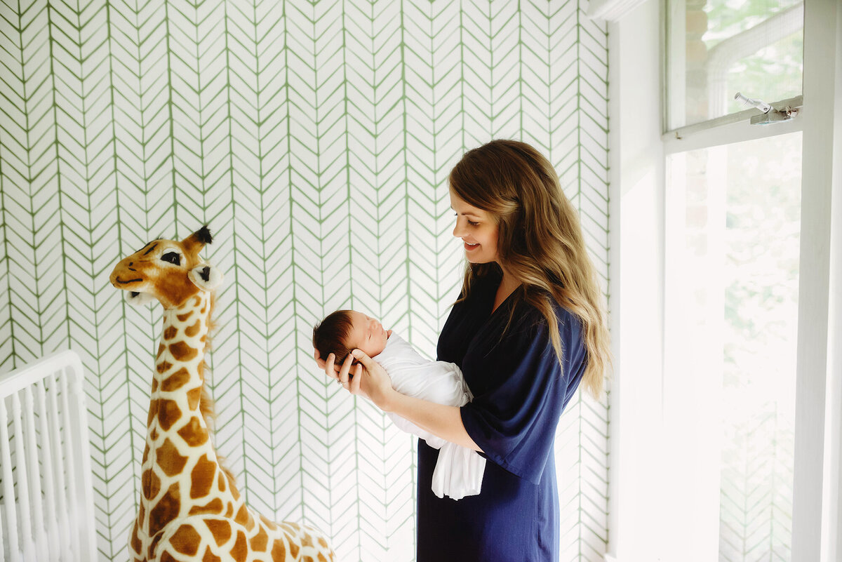 Charleston’s #1 Lifestyle Newborn Photographer, mother holding her infant for Newborn Photoshoot in Charleston, SC.