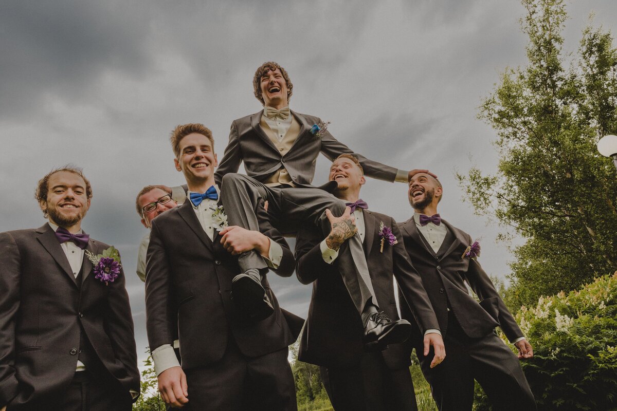 A Groom is raised up on the shoulders of his groomsmen