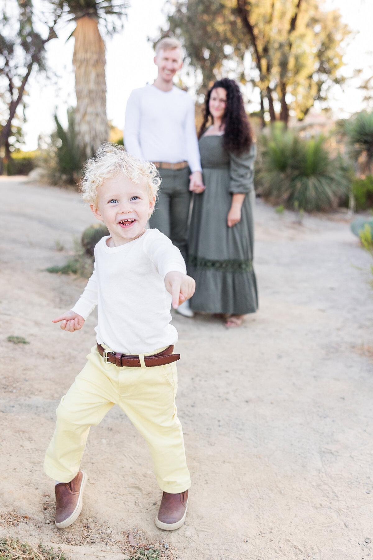 boy walking in front of parents in Cactus garden Balboa Park San Diego
