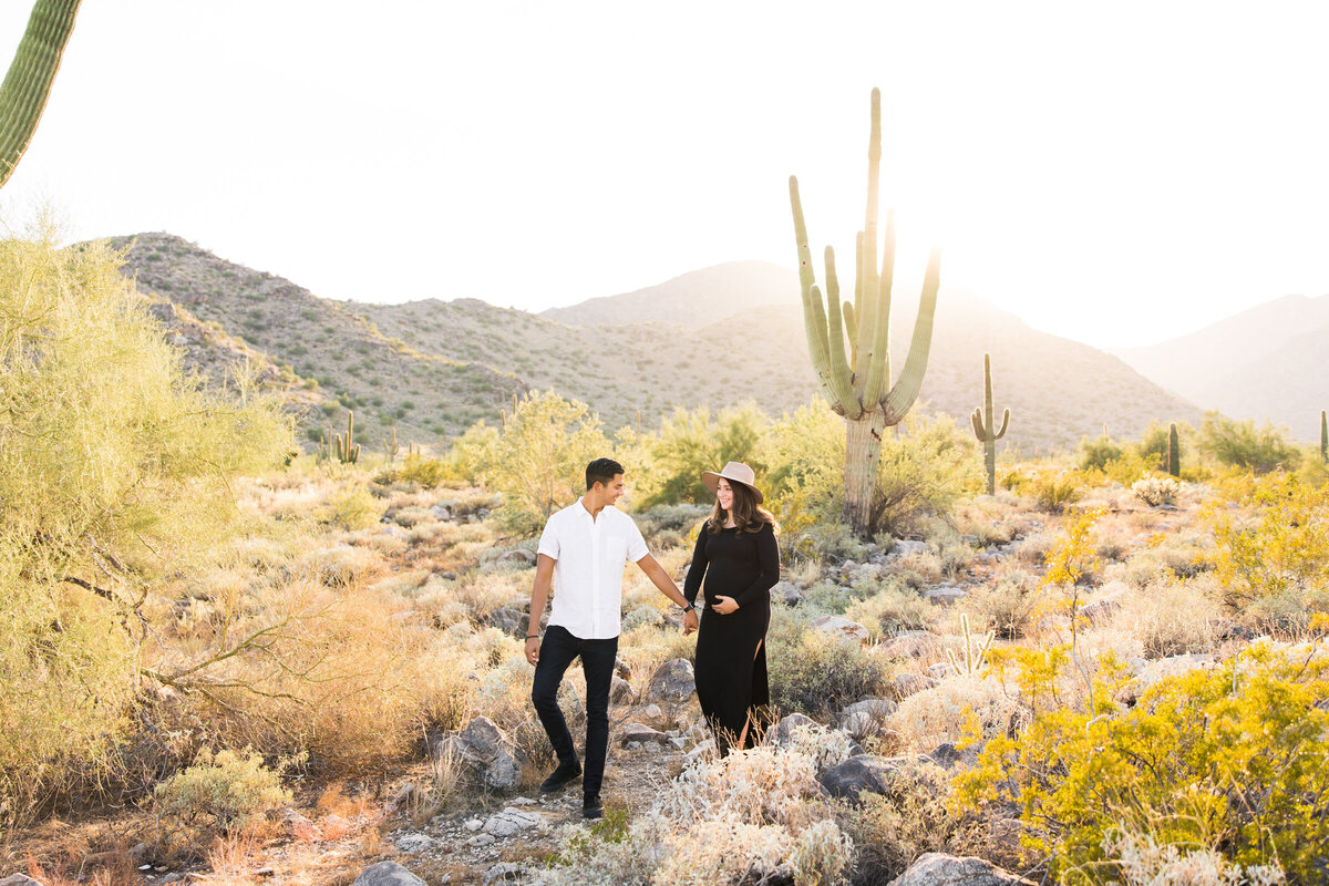 mom and dad to be posing for maternity photo in Phoenix desert