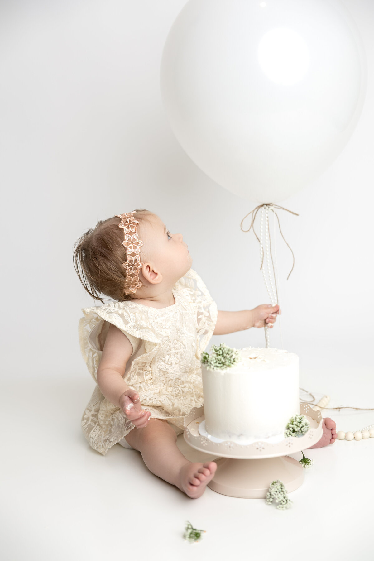 Minimalist cake smash with large white balloon and greenery