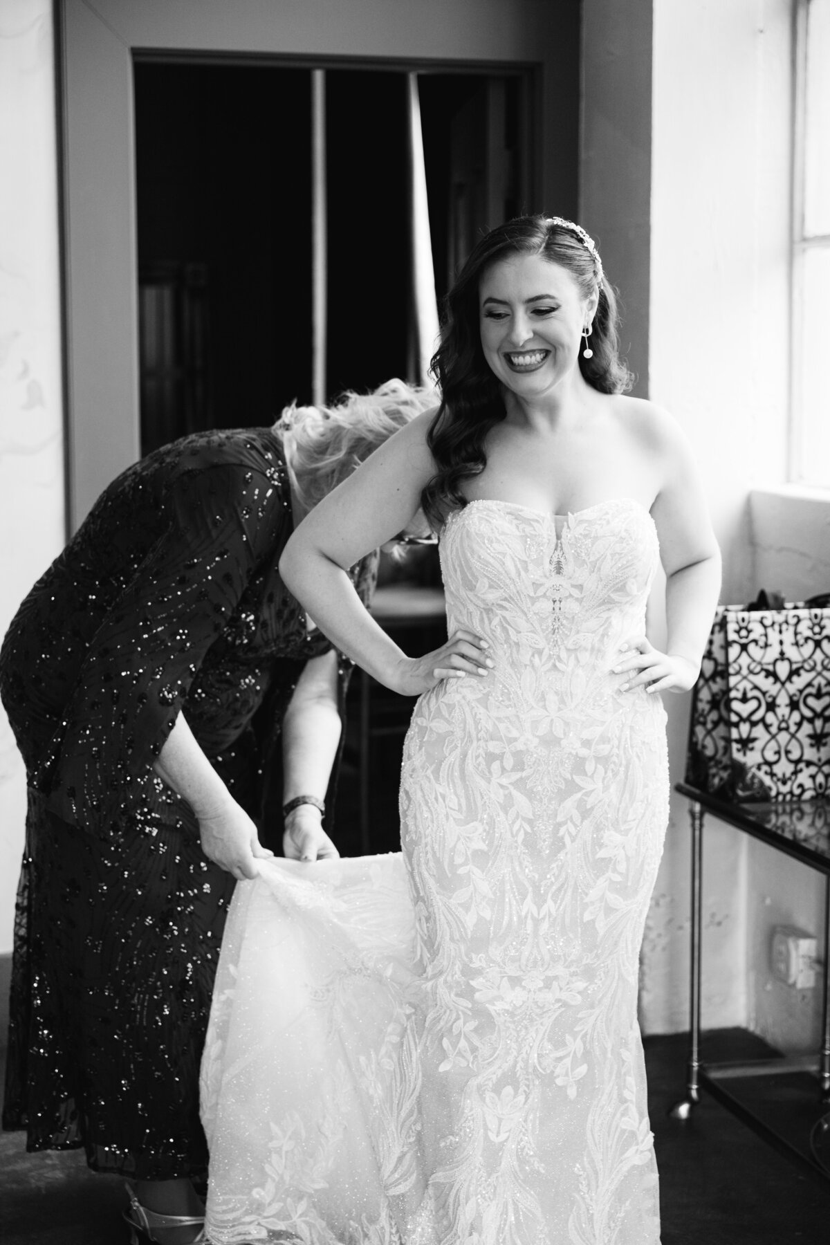 black and white portrait mother of the bride helping button dress