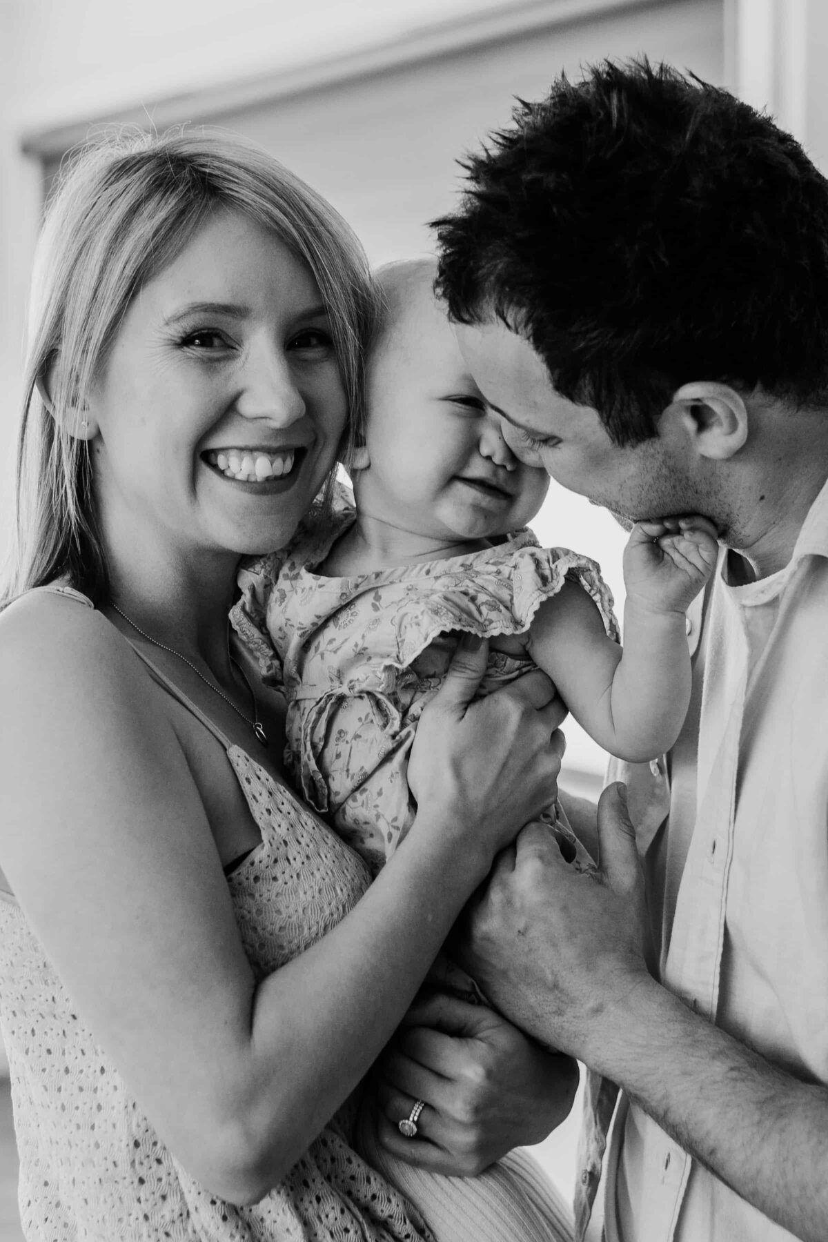 Black and white image of mum, dad and toddler standing together, Family Photography Gift Vouchers Melbourne