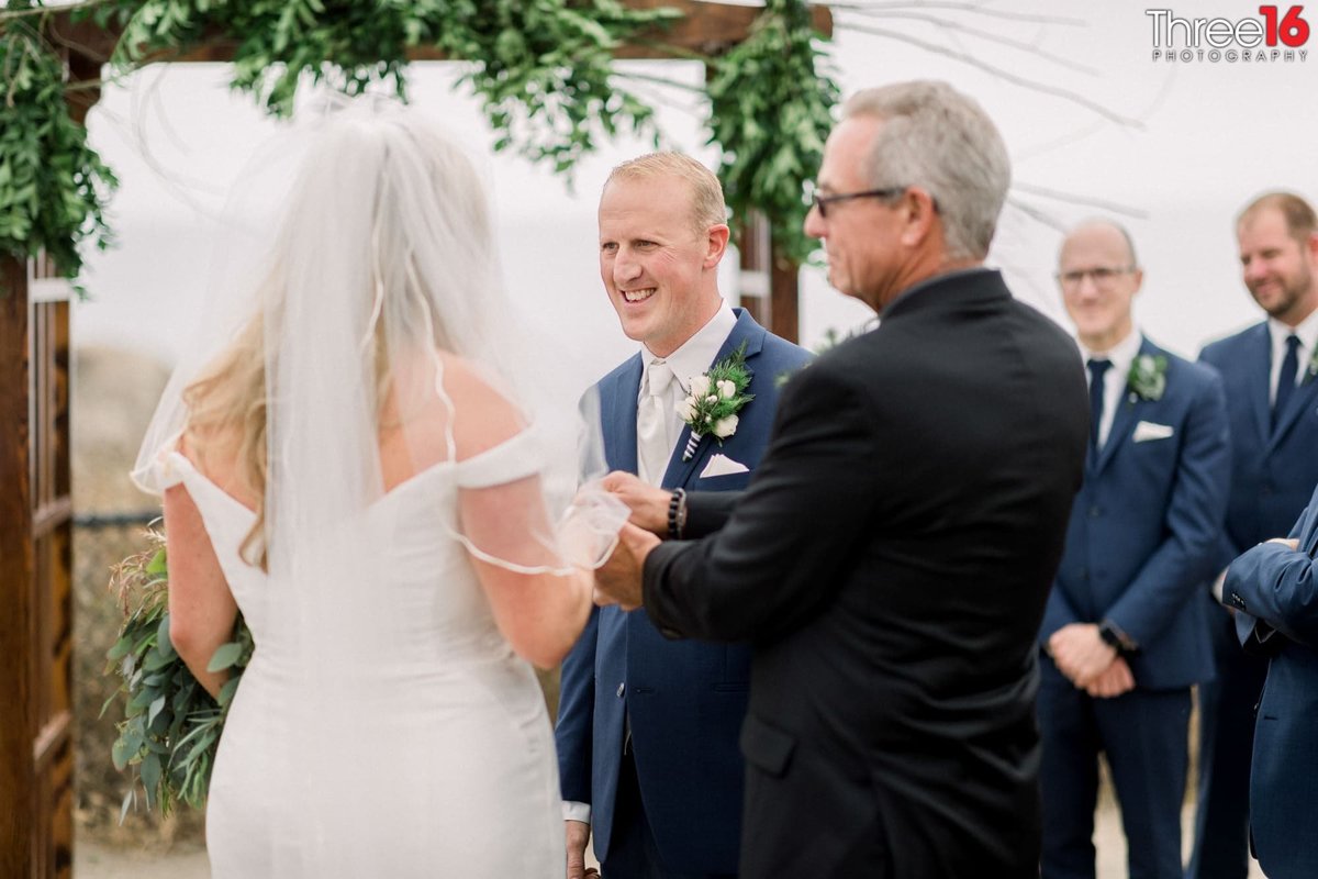 Groom smiles at his Bride during the wedding ceremony