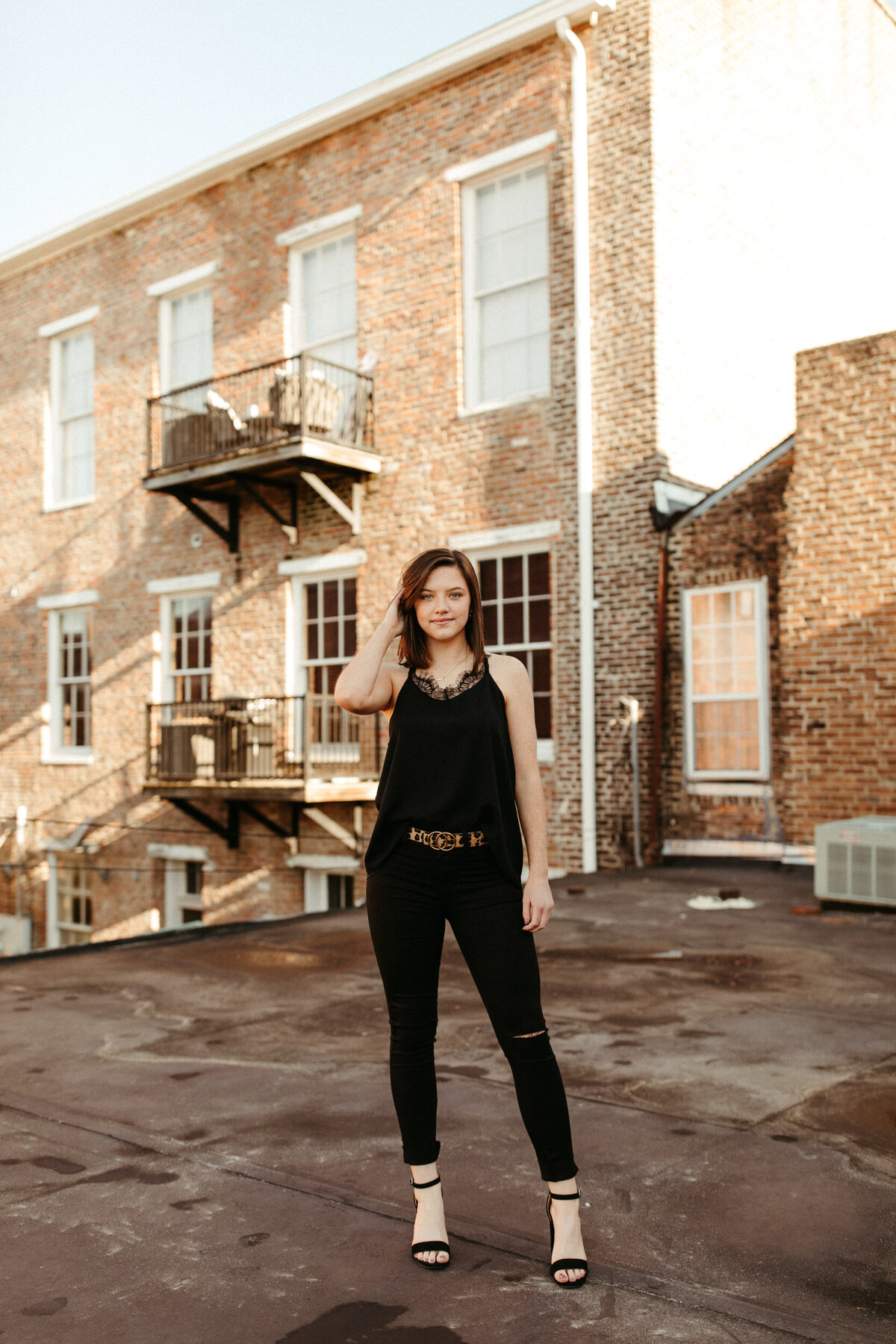 Senior girl posing on a rooftop of a downtown building