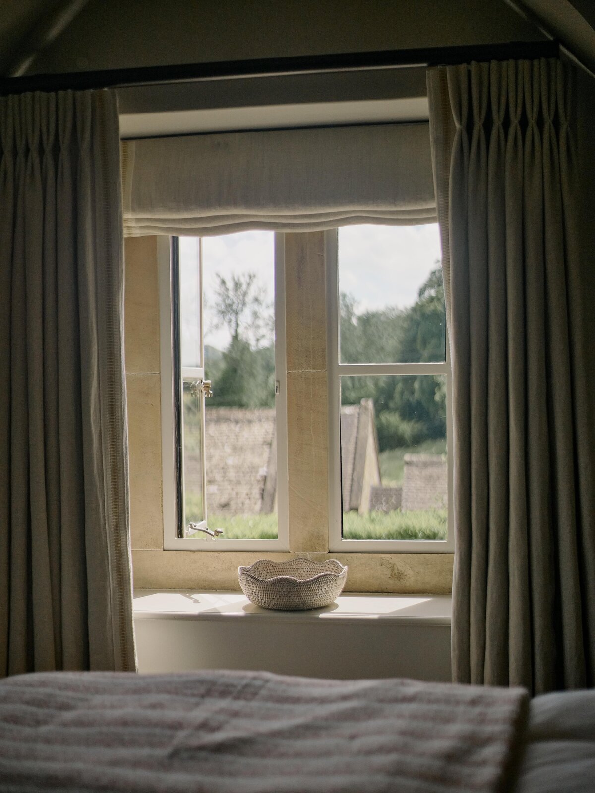 Master bedroom with light falling onto windowsill and the carved bowl