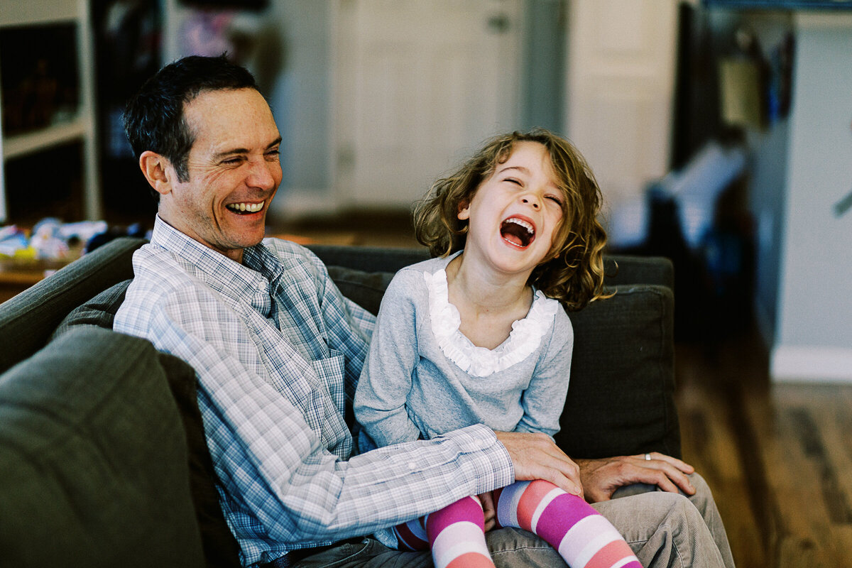daughter and father laugh during in home photo session