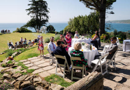 A group of wedding guests sitting around a table on a patio