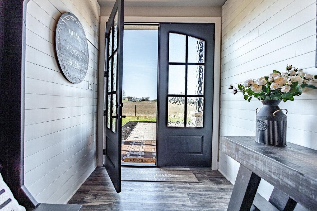 Entryway with farmhouse deocr in this five-bedroom, 3-bathroom vacation rental house for up to 10 guests with free wifi, private parking, outdoor games and seating, and bbq grill on 2 acres of land near Waco, TX.