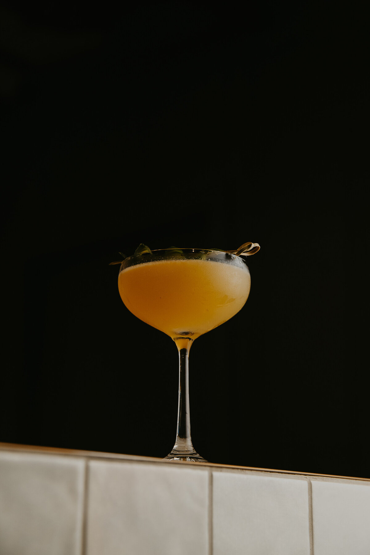 yellow cocktail on a bar.
