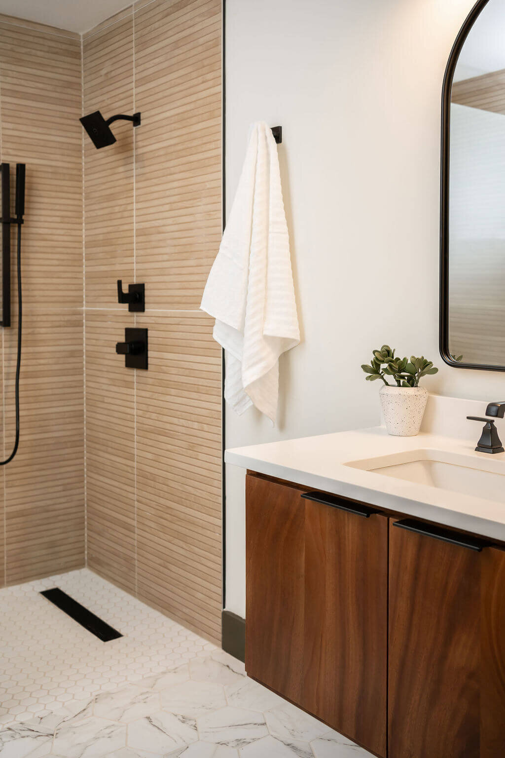 sweet southern home mid mod tiled shower and wooden vanity in bathroom