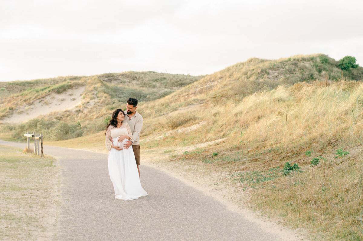 pregnant couple in the sand dunes in Bloemendaal, a beach with sand dunes near Amsterdam