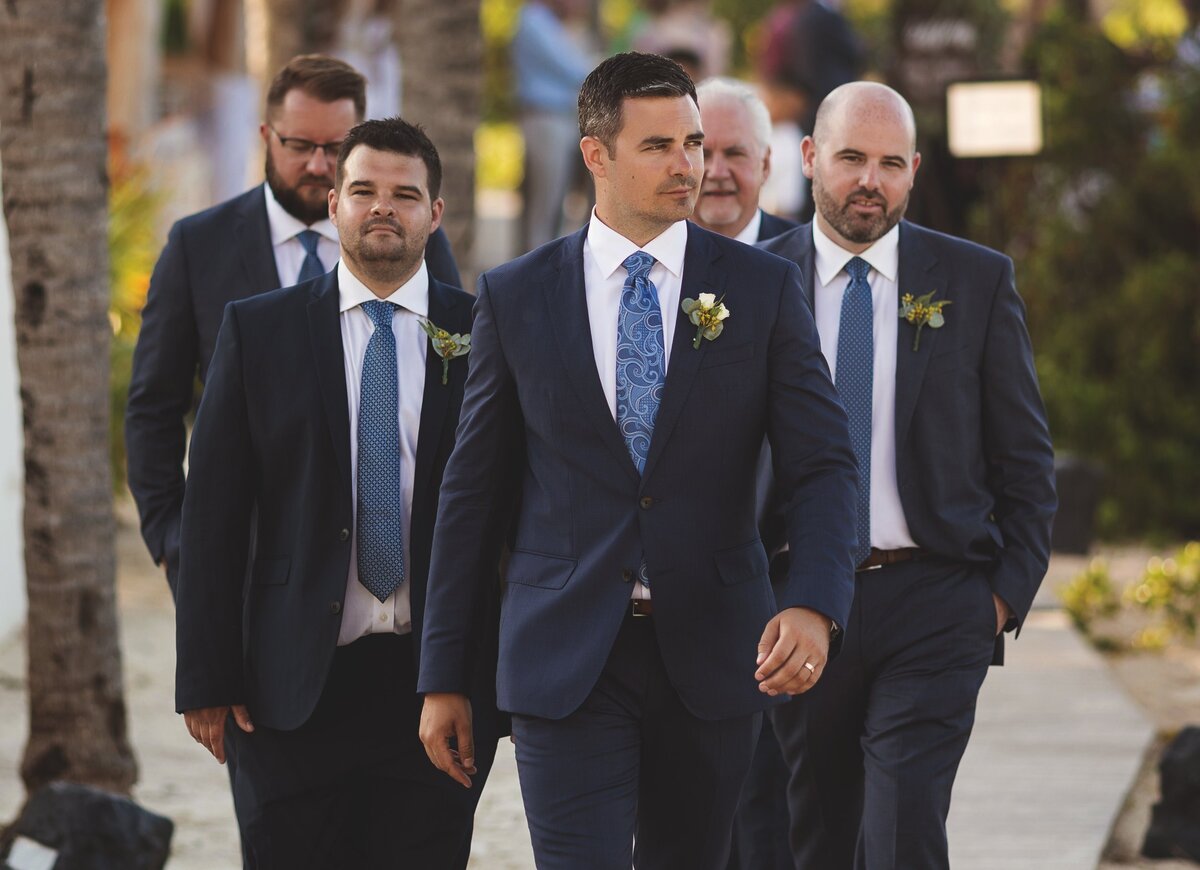Groom walking with groomsmen at wedding in Cancun