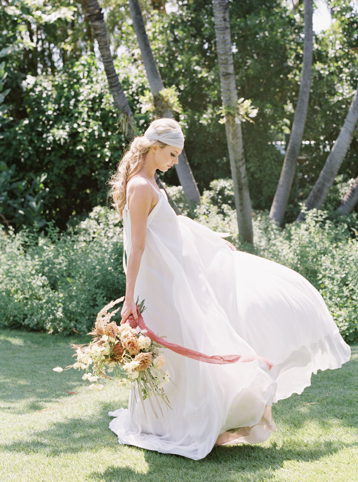 Headscarf Bride swooshes around in her dress with bouquet.