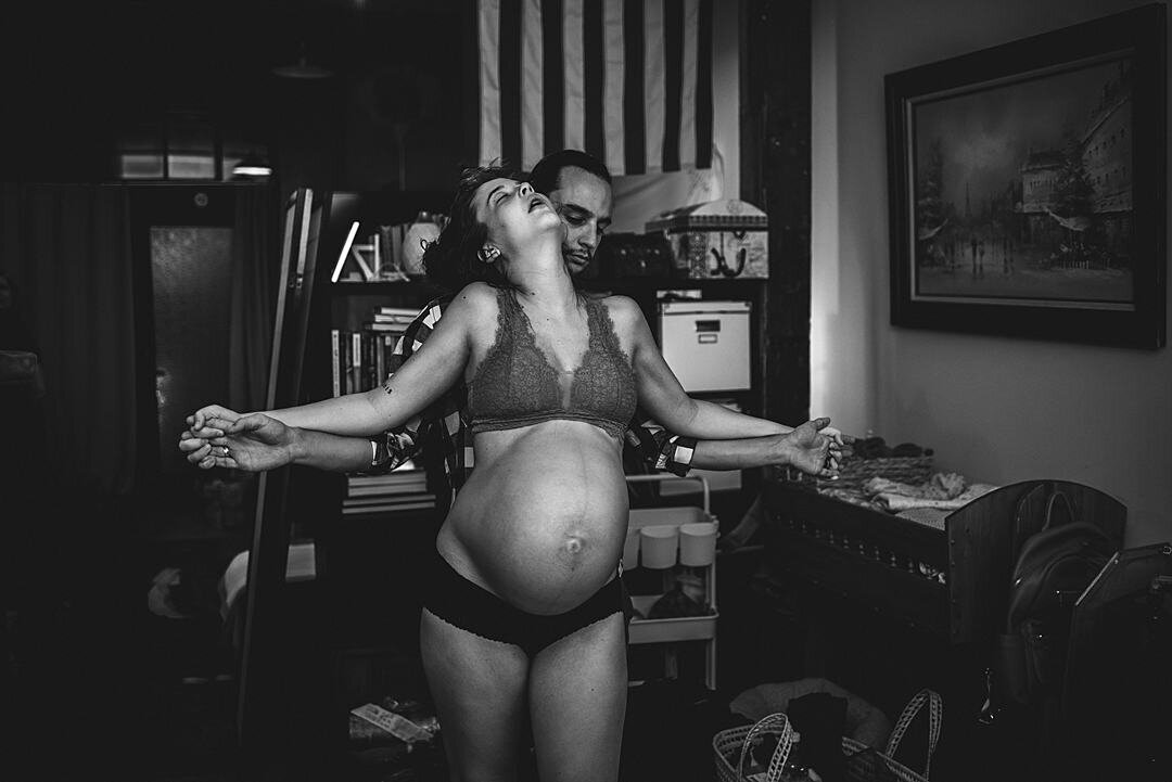 A candid shot of a partner or loved one supporting the birthing person through labor, emphasizing the importance of teamwork and emotional support during birth.