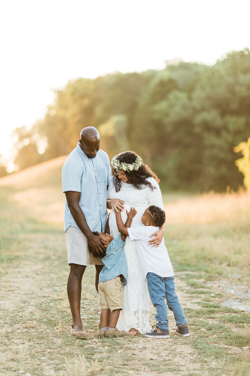golden hour portrait of black family hugging each other in a field