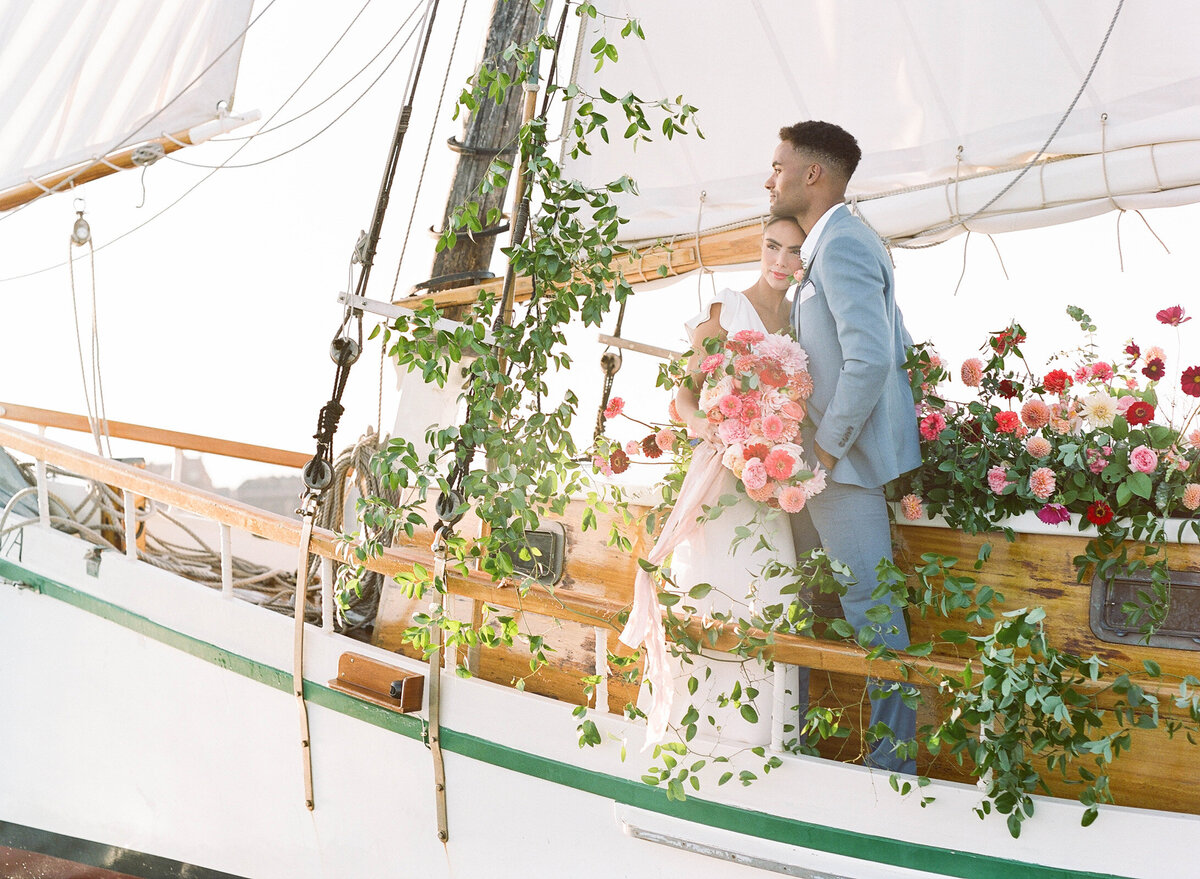Kate-Murtaugh-Events-elopement-wedding-planner-Boston-Harbor-sailing-sail-boat-yacht-greenery-floral-installation-couple-embrace-golden-hour