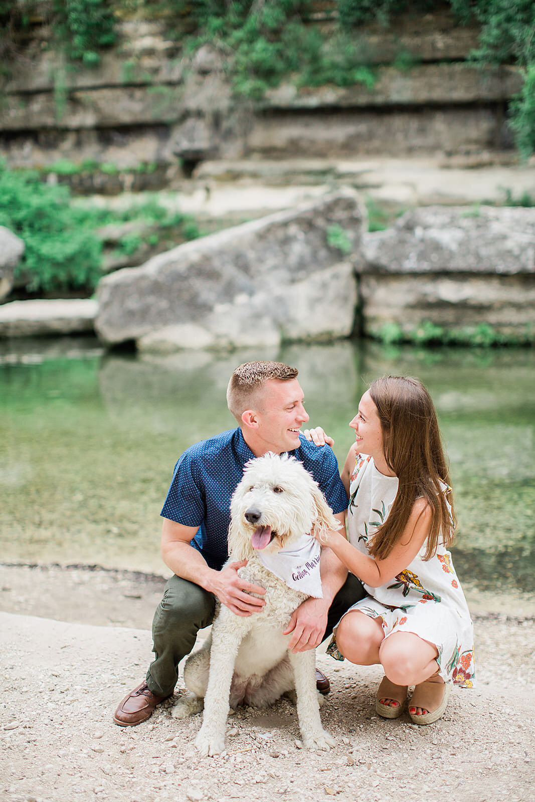 a couple poses with their dog for their engagement photos at Bull Creek