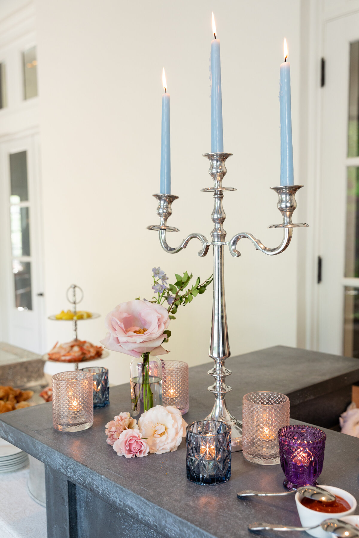 Bridgerton inspired engagement party at a private home in Nashville, TN with lush, organic florals of wisteria, spanish moss, and pastel blooms. Silver candelabra with light blue tapers and styled flowers.