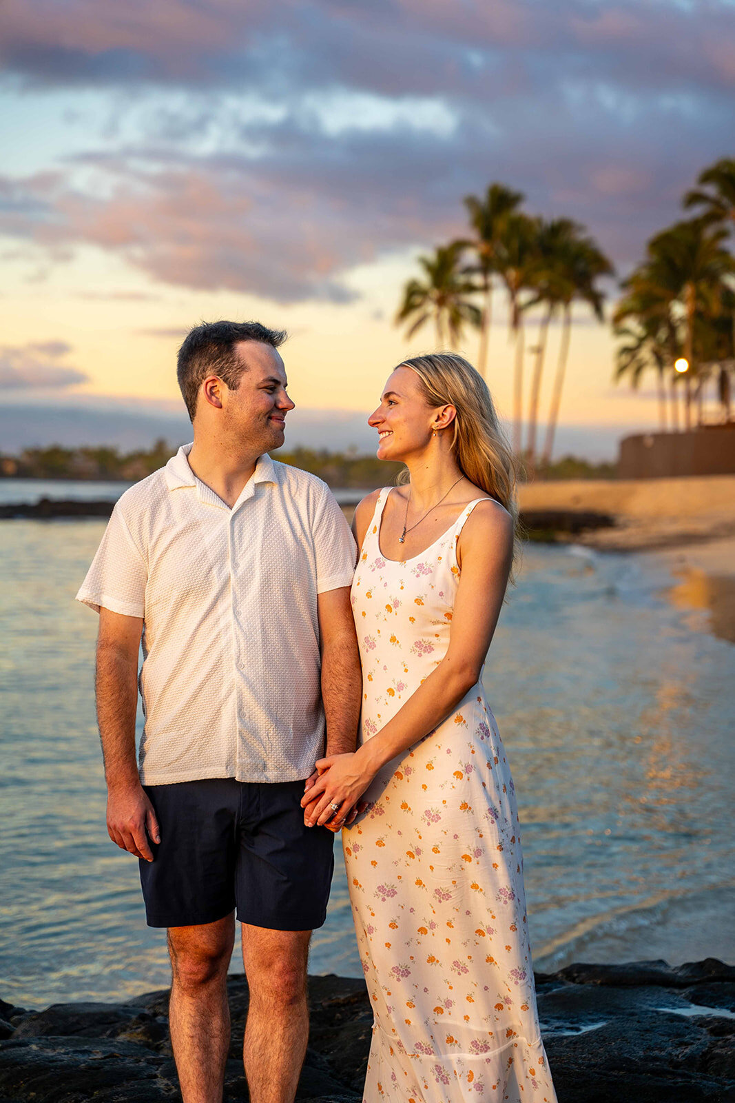 Couple holding hands for Hawaii engagement photos during sunset