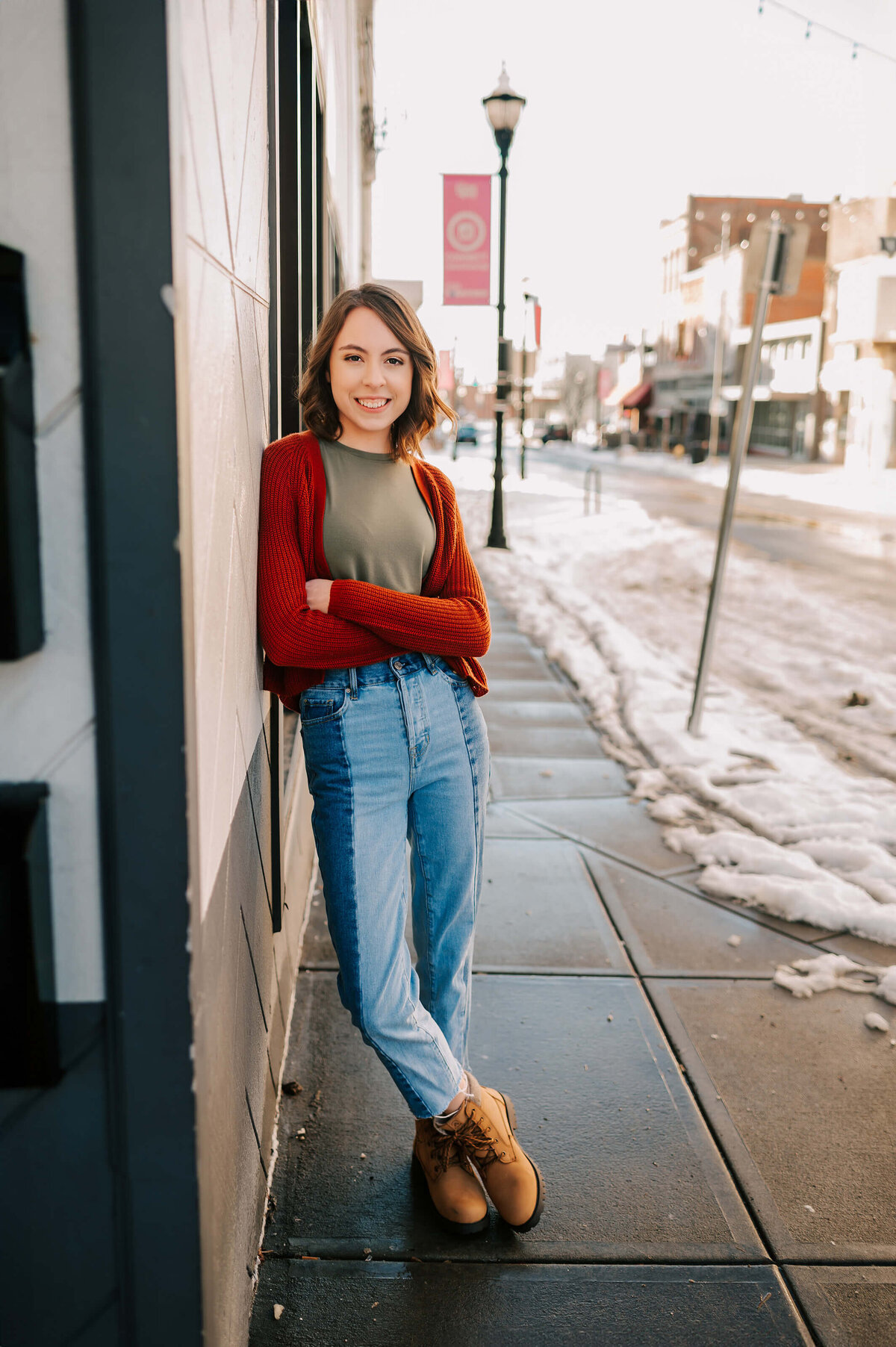 girl leaning against brick wall at Branson landing during Branson senior photography session