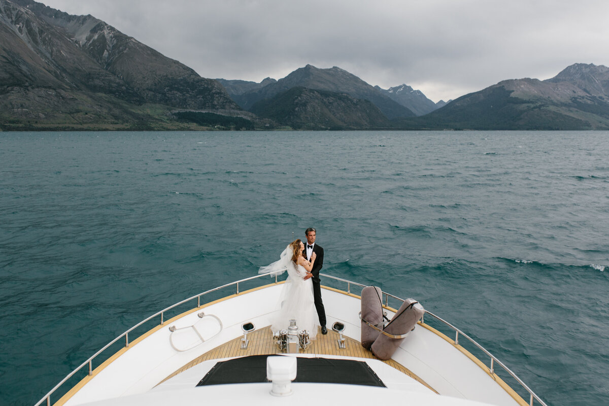 The Lovers Elopement Co - wedding photography - bride and groom at front of boat on Queenstown lake