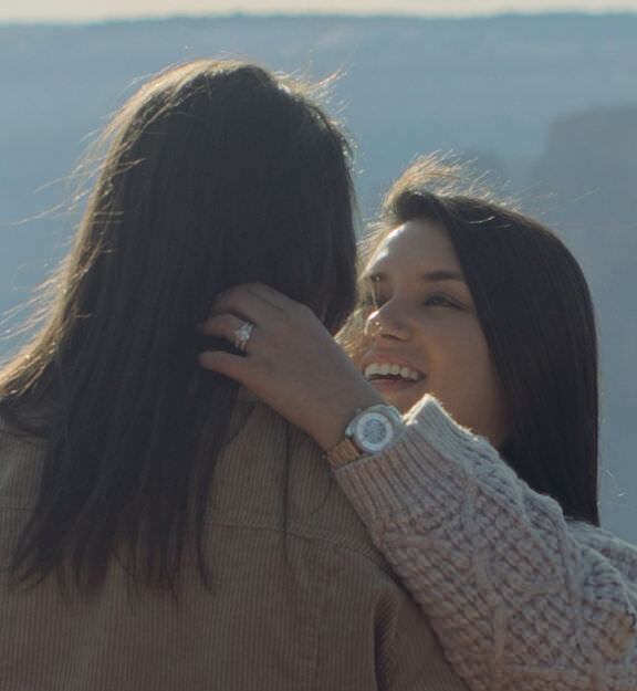 A person smiling as they hold their partner.